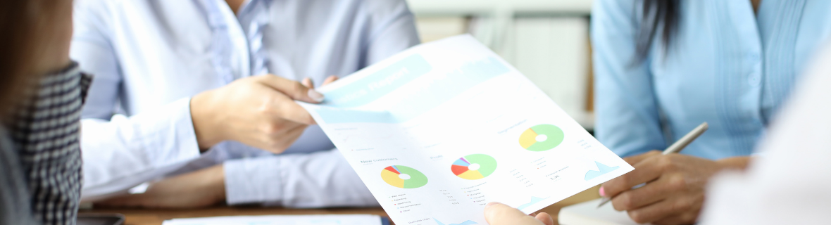 People's hands holding a sheet of paper with a graph on it