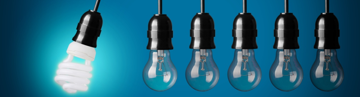 A series of incandescent lightbulbs, with the final glowing bulb as a CFL.